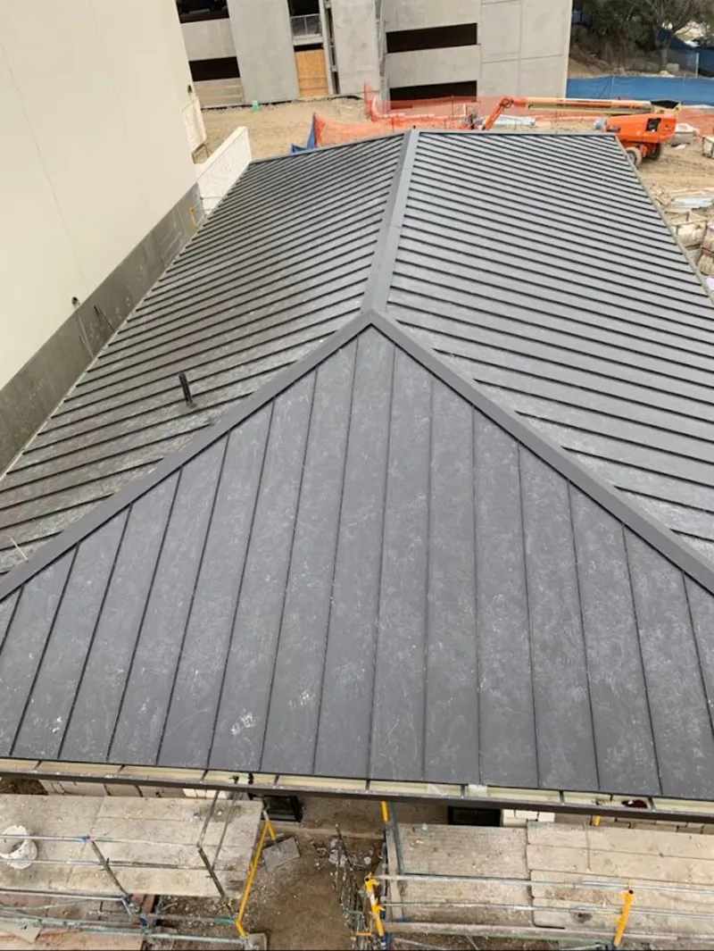 Commercial metal roof construction with crane equipment in Littleton